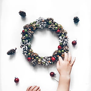 person touching Christmas wreath decor thumbnail