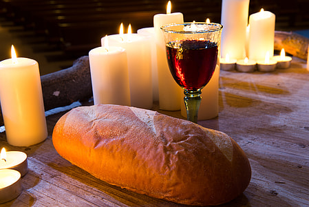 bread and wine surrounded by pillar candles thumbnail
