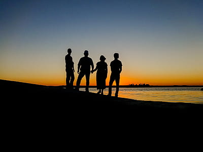silhouette of four people standing during golden hour thumbnail