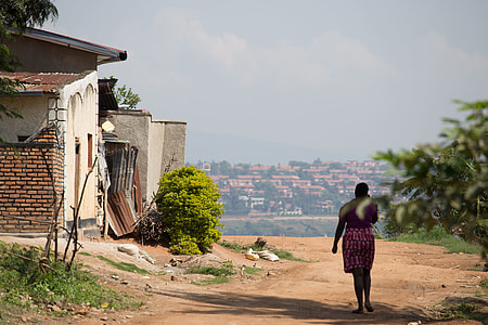 woman walking down the street near houses thumbnail