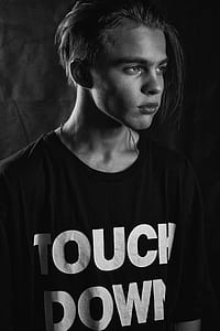 grayscale photo of man standing while wearing touch down printed shirt thumbnail