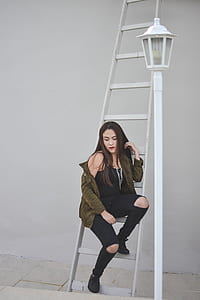 woman sitting on gray metal ladder beside the lanternt thumbnail