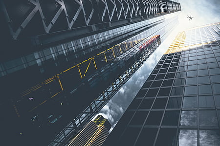 worm's eye view photography of drone over glass buildings during daytime thumbnail