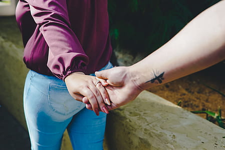 man and woman holding hand during daytime thumbnail