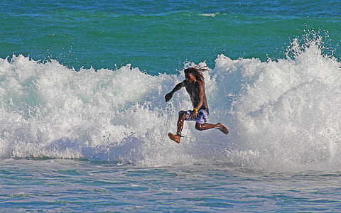 man jumping off sea wave thumbnail