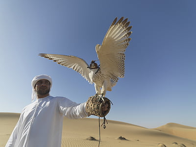 man wearing white thobe coat holding white bird thumbnail