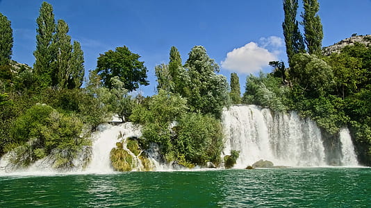waterfalls and green trees under sunny sky thumbnail