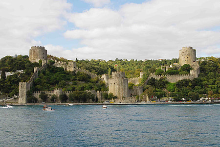 beige castle beside sea with boats landscape photography at daytime thumbnail