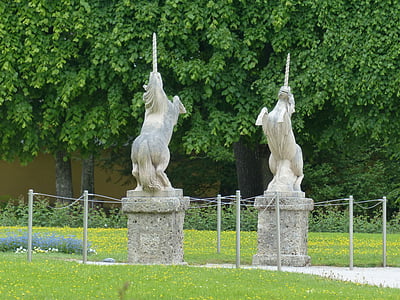 two concrete unicorn statues near green leafed trees thumbnail