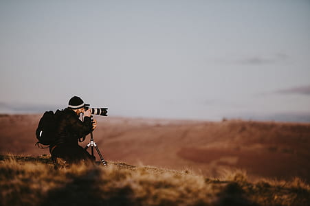 man holding black DSLR camera taking photo thumbnail