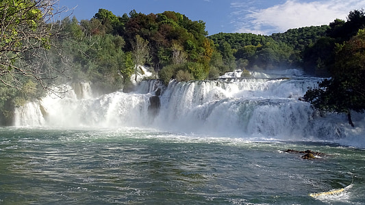 waterfall surrounded by trees during daytime thumbnail