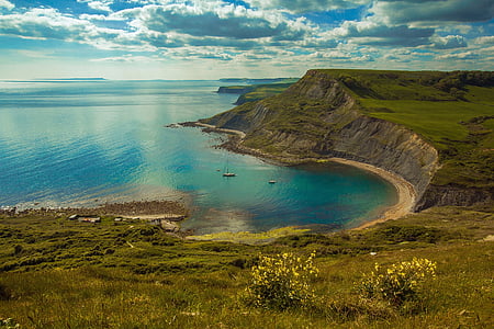 green hill near sea at daytime thumbnail