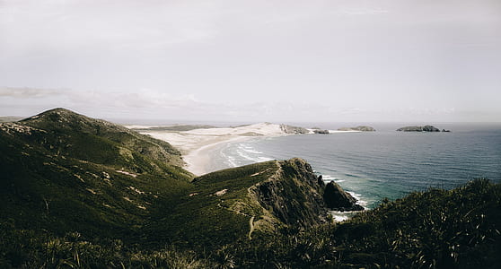 aerial photo of body of water near mountain thumbnail