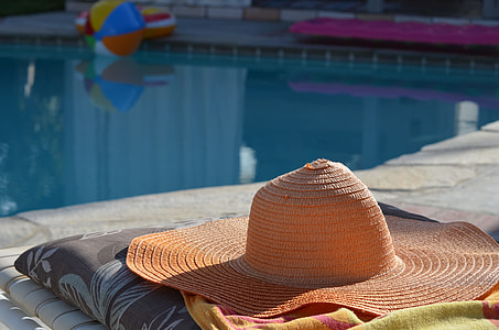 beige sunhat on yellow textile near pool thumbnail