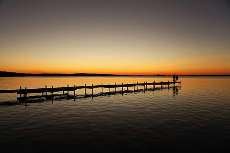 silhouette photo of breakwater bridge during golden hour thumbnail