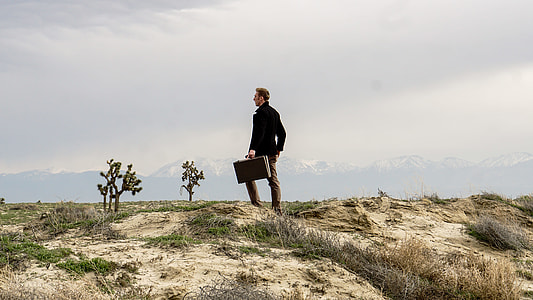 man standing on green grass field under white sky during daytime thumbnail