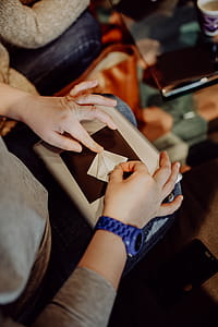 Women folding sheet of paper while making origami thumbnail