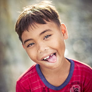 boy in pink crew-neck top sticking out tongue thumbnail