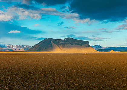brown mountain beside desert during daytime thumbnail