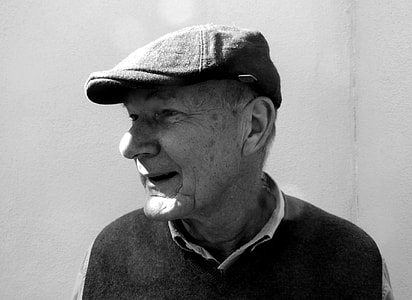grayscale photo of man wearing hat and collared shirt thumbnail