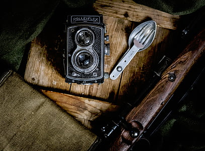 black Rolleflex point-and-shoot camera on brown wood plank thumbnail