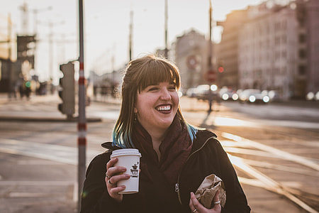 woman smiling holding disposable cup and paper pack thumbnail