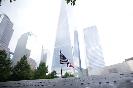 A small American flag in New York with skyscrapers in the backdrop thumbnail