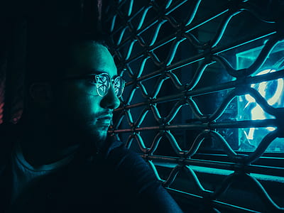 man looking thru metal grille thumbnail