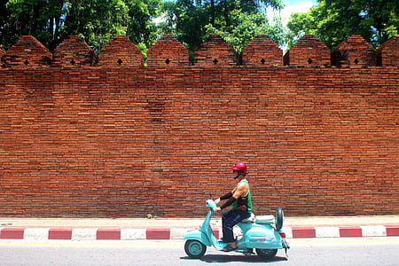 person riding motor scooter on roadway thumbnail