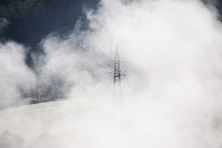 gray electric pole surrounded by clouds thumbnail