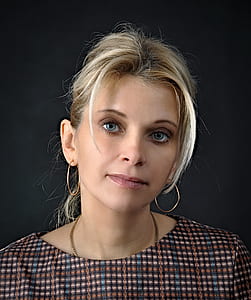 woman wears brown crew-neck top with gold-colored earrings and necklace thumbnail