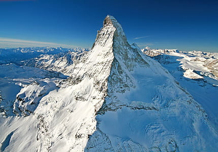 mountain covered with white snow under blue sky aerial photography thumbnail