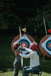 woman teaching toddler to shoot arrow thumbnail
