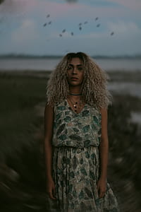 selective focus photography of woman standing on gray field thumbnail