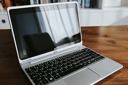 Silver laptop with various items on a table thumbnail