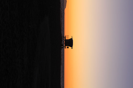 silhouette of watch tower near body of water thumbnail