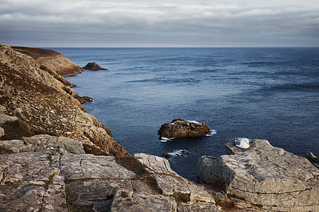 photo of rock formations near body of water thumbnail