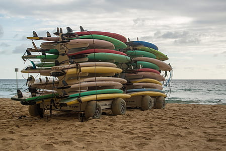 surfing boards on trailer near body of water thumbnail