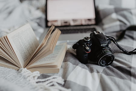 A camera, MacBook, and a book waiting in bed thumbnail