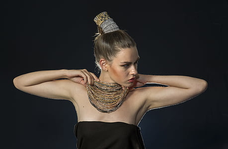 woman holding gold-colored necklace thumbnail