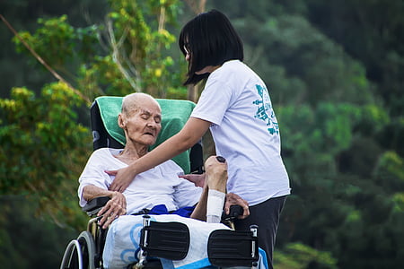 grandfather sitting on wheel chair beside girl thumbnail