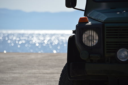 black vehicle in distant of body of water thumbnail