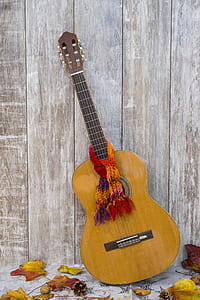 brown classical guitar leaning on wooden wall thumbnail