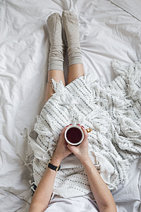 Soft photo of woman on the bed with the book and cup of coffee in hands thumbnail