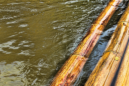 three brown bamboo rods floating on body of water thumbnail