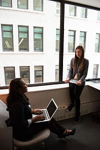 Two Women Talking White Holding Laptop Computers thumbnail