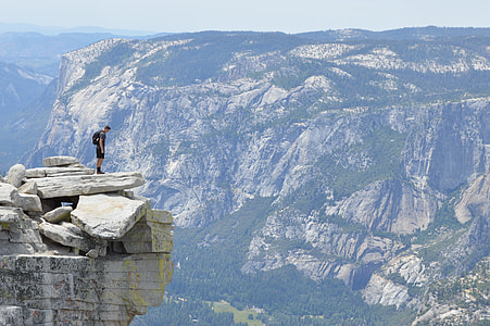 man standing on cliff during daytime thumbnail