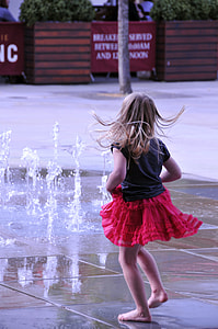 girl playing beside water fountain thumbnail