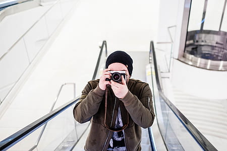 man on skalator using DSLR camera thumbnail