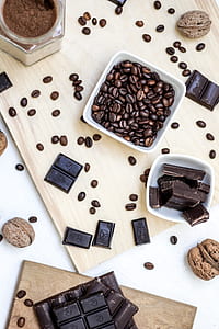 coffee beads beside chocolate bars and walnut on table thumbnail